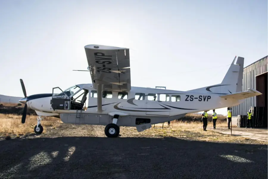 Ground crew loading boxed cargo into the hold of a Beechcraft aircraft