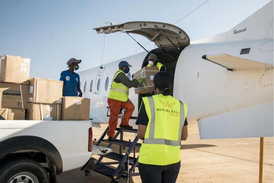 Two Mohahlaula Airlines crew members overseeing loading at an aircraft door